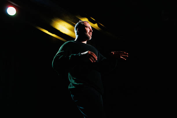 Actor in casual clothes rehearsing on scene with spotlight