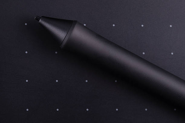Close-up of a digital stylus on a dark background with dotted grid, ideal for creative, tech, and design concepts.