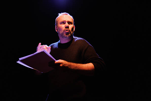 istock Dramatic actor with scenario rehearsing on theater scene with lighting 2247413713