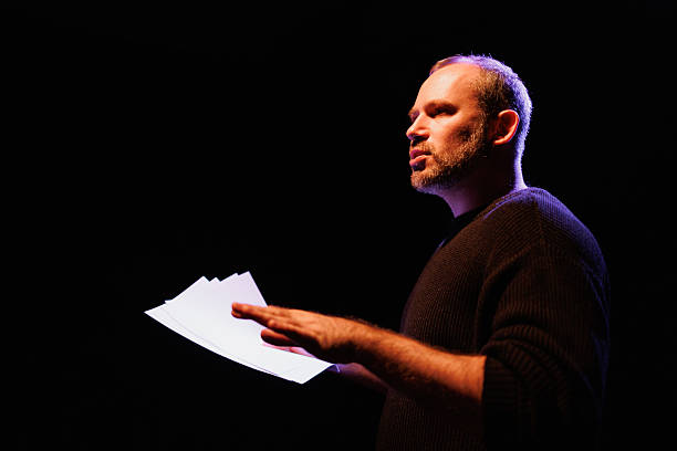 istock Portrait of actor in sweatshirt holding scenario on stage with light 2247413827