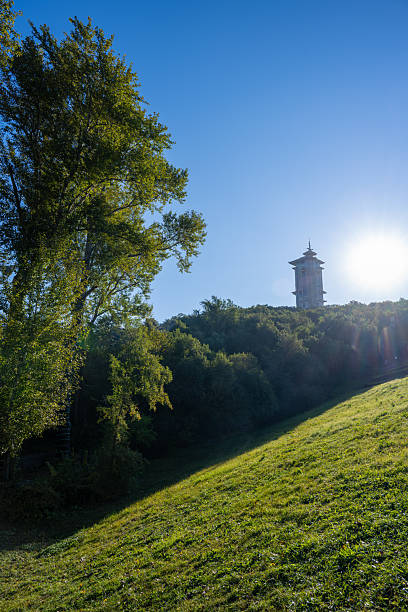 istock A Tower on a Hillside Surrounded by Lush Green Trees and Bathed in Sunlight 2247414562