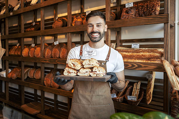 istock Smiling baker working in bakery holding sandwiches 2247418243