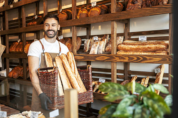 istock Male Baker Transporting Freshly Baked Bread in Shop 2247418259