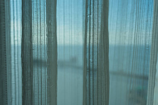 istock Sheer white curtain, allowing light to filter through. 2247422119