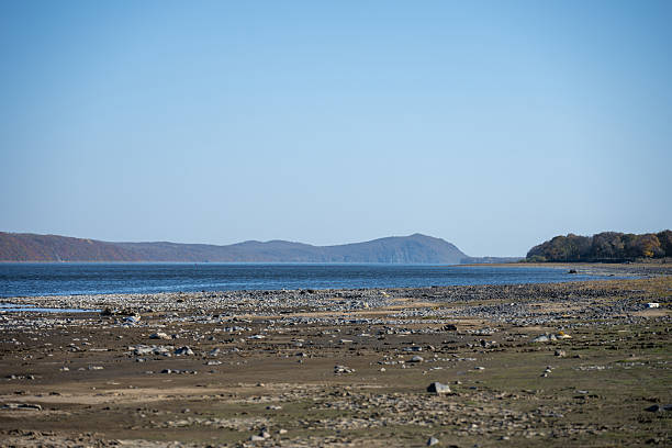 istock Serene Riverbank Landscape with Distant Mountains and Clear Blue Sky in Harmony 2247423221