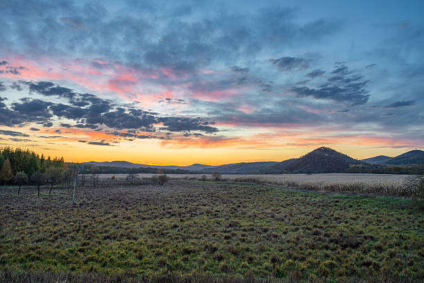 istock A Serene Rural Landscape at Sunset with Vibrant Sky and Rolling Hills 2247423529