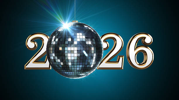 A golden “2026” set displayed with a shiny disco ball hanging in front, creating a festive party atmosphere. The disco ball reflects tiny square highlights, adding sparkle and movement against the dark background. The contrast makes the gold numbers stand out clearly, giving the visual a classy New Year celebration vibe. Ideal for holiday intros, party promos, and New Year greeting visuals.