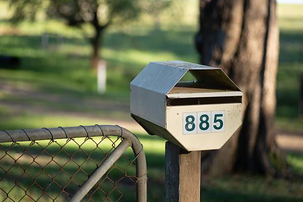 Mailbox with the Number 885 printed on is standing next to a gate in a rural setting