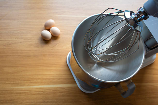istock A Kitchen Stand Mixer with a Wire Whip Attachment and Three Eggs on a Wooden Countertop Ready for Baking 2247427573