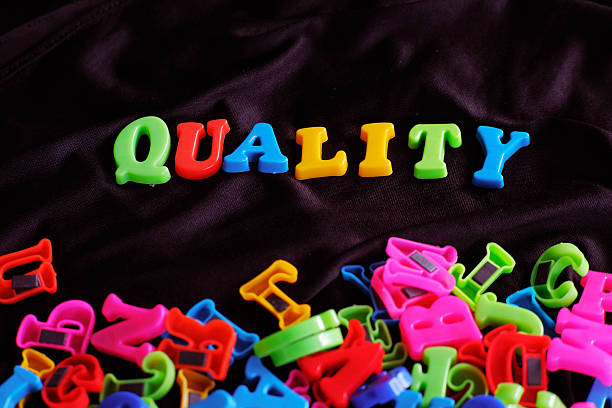 istock Colorful Plastic Letters Forming the Word Quality on Fabric Background 2247427713