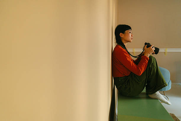 Photo of a Japanese woman holding a digital camera. She is going through the gallery on her camera.