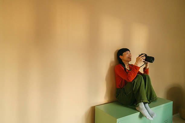 Photo of a Japanese woman holding a digital camera. She is going through the gallery on her camera.