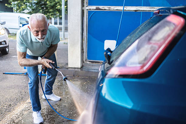 istock Man using high pressure washer to clean a car at a self-service wash. 2247429986