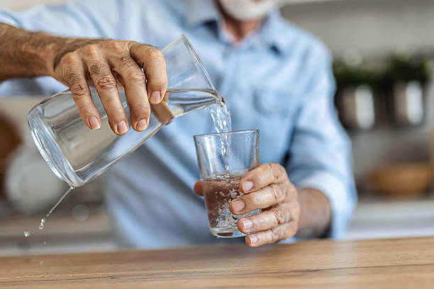 istock Thinking, senior man and drink water for hydration, reflection and remember past life in kitchen. Elderly person, glass and refreshing beverage with thoughts, memory and future wellness at house. 2247430145