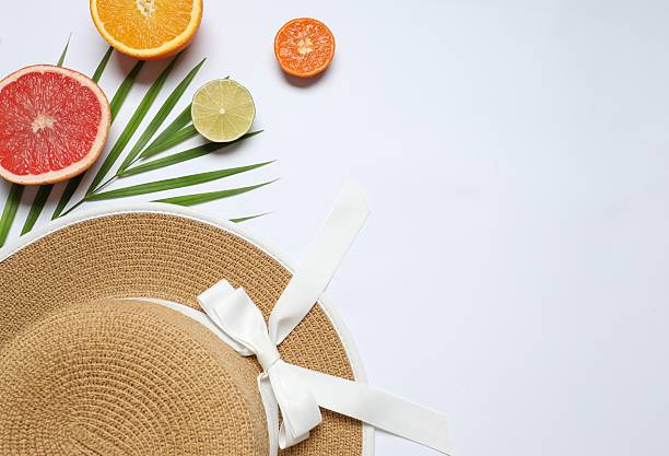 Top view of various colorful fruit and stylish summer hat on table background. Summer concept. Flat lay. Top view with copy space for text.