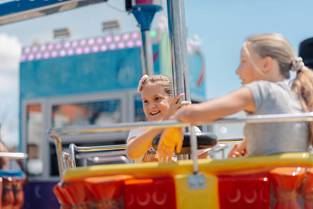 istock Two cheerful girls having fun on a carnival ride 2247432351