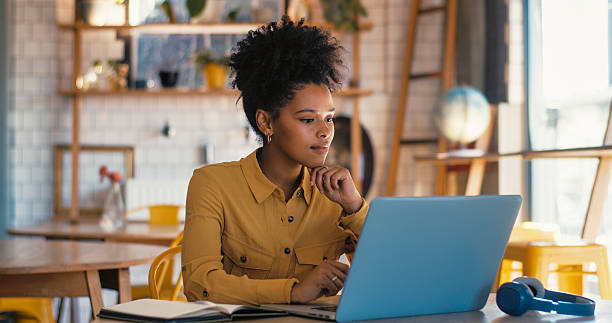 istock Young woman concentrates while using laptop in coffee shop. 2247432660