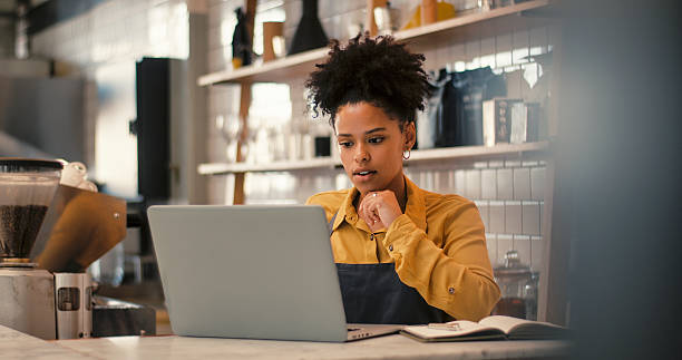 istock Young woman working in a restaurant, using laptop 2247433034