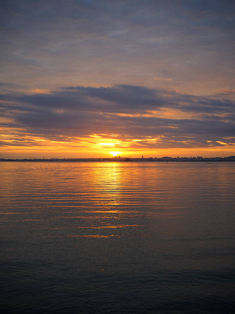 istock A Serene Sea Surface at Sunset with Golden Reflections and Cloudy Sky 2247433133
