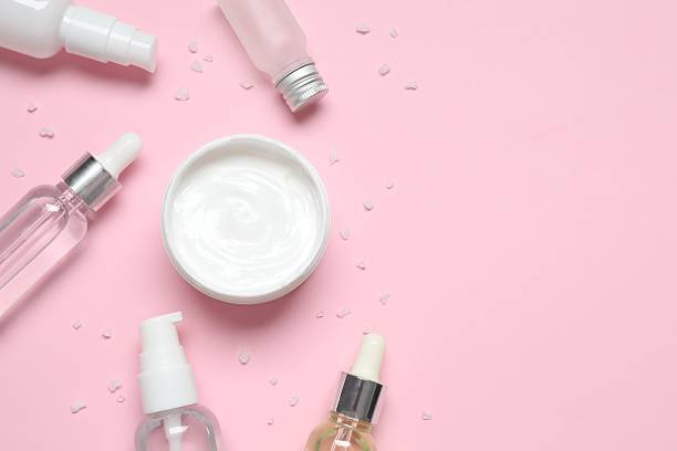 istock Flat lay composition with cosmetics on pink background. Top view organic hand cream, natural homemade essential oils. 2247433812