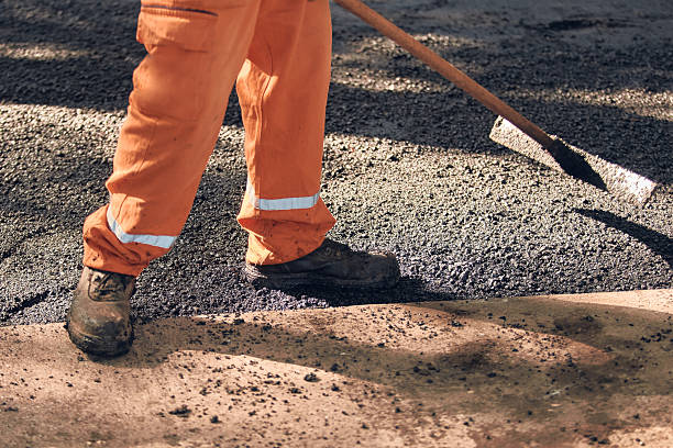 istock Construction worker working on a new asphalt layer on a public street. 2247436360