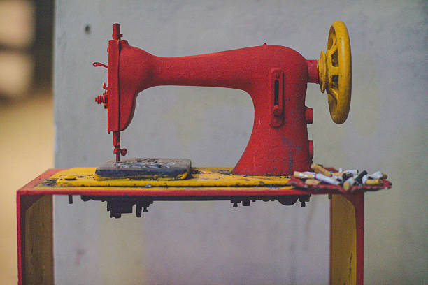 Vintage red sewing machine on display with artistic paint splatters.
