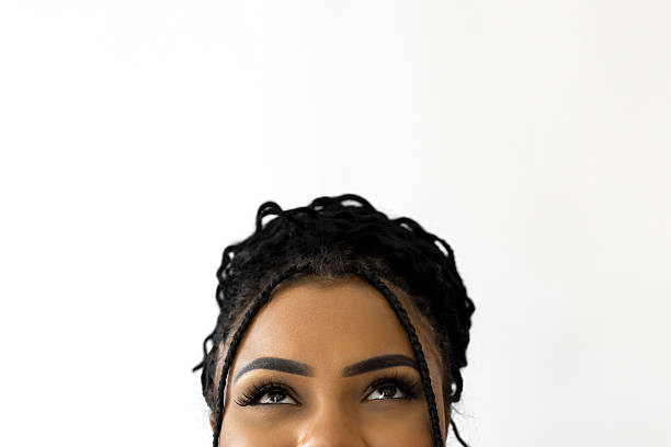 Young black woman looking up against white background