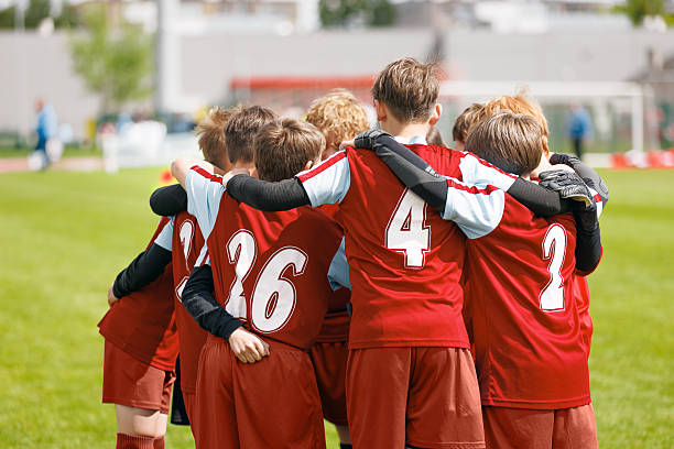istock Youth Soccer Team Huddling Together. Kids in Red Jerseys Showing Teamwork and Unity Before Football Match 2247440146
