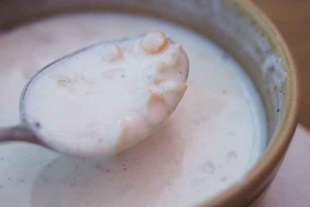 A spoonful of creamy soup features grains in a rustic bowl.