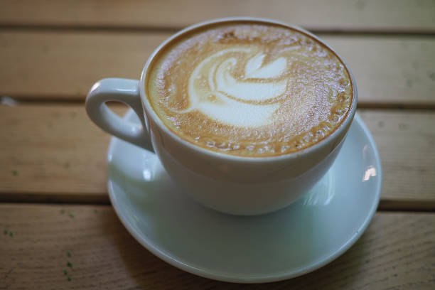 istock Perfectly crafted coffee cup with latte art on wooden table 2247454863