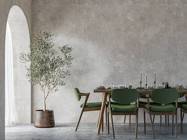istock A minimalist simple dining room interior with a full (set) table and chairs, a potted plant in front of a weathered wall, on concrete floor, arched doorway or window with curtains, '70s retro style furniture 2247455252