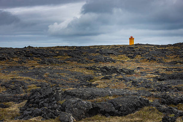 characteristic orange lighthouse at Svortuloft, a 4-kilometer-long coastal cliff located on the westernmost point of the Snæfellsnes peninsula in West Iceland; Svortuloft, Iceland