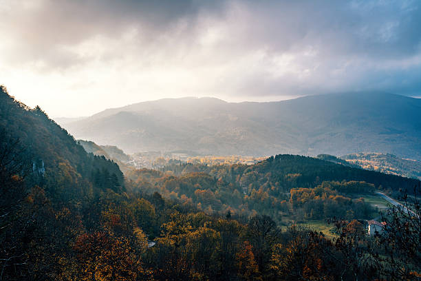 Landscape of mountains, clouds and sun going west. Carpathians mountains in august, west Ukraine. Nature background. Sun illuminating white clouds in the evening. Blurred background