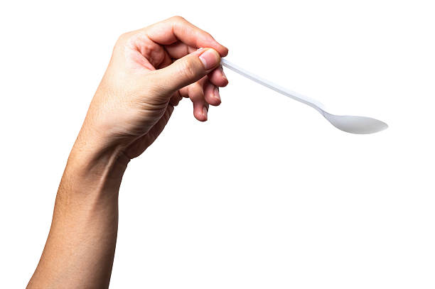 istock Male hand holding a white plastic spoon isolated on white background. 2247457654