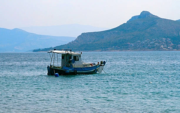 istock Small fishing boat with mountain backdrop 2247457737