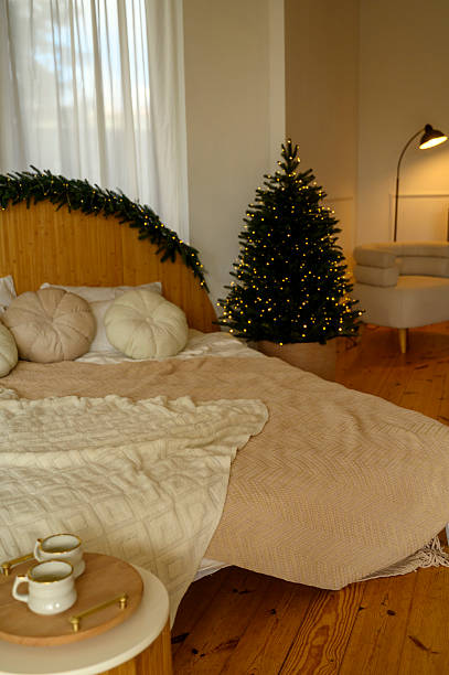 istock bright bedroom with a Christmas tree. A cozy bedroom interior with a bed 2247457908
