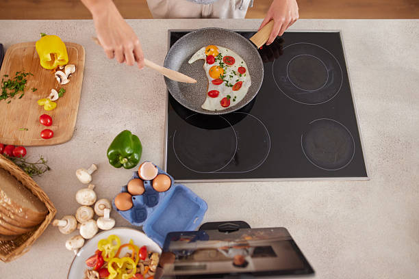 istock Woman cooking healthy breakfast with fried eggs and vegetables 2247458362