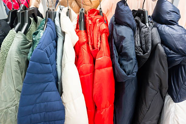 istock Colorful winter jackets displayed on hangers in a retail store, showcasing various styles and fabrics in bright and muted tones 2247458655