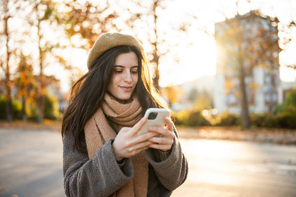 istock Autumn Lifestyle: Smiling Woman Browsing Her Smartphone 2247459090
