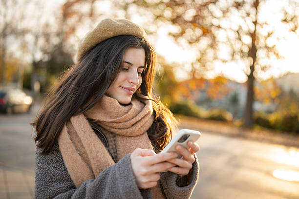 istock elaxed Woman Scrolling on Her Phone Amid Autumn Leaves 2247459101