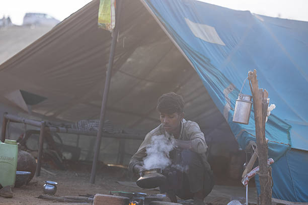 Pushkar, Rajasthan, India - November 2024: Portrait of a rajasthani male in traditional clothes cooking food at desert fair ground during the pushkar camel fair.