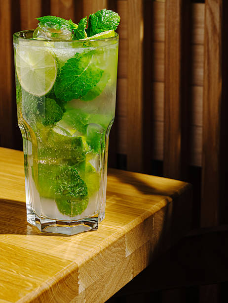 istock Refreshing mojito with mint and lime on wooden table in cozy setting 2247459548