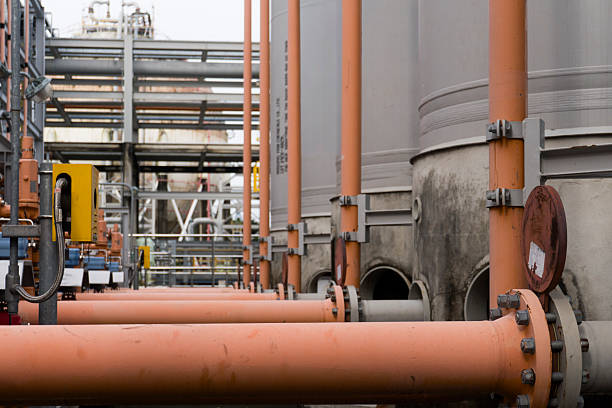 Large industrial plant with many pipes and tanks. The pipes are orange and the tanks are gray