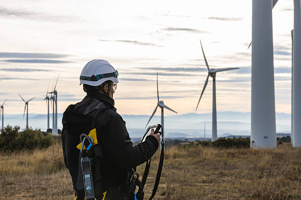 An engineer using a digital tablet, preparing to access the wind turbine for inspections.