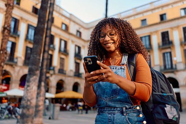 istock Happy black woman using smartphone while traveling in Barcelona 2247462752