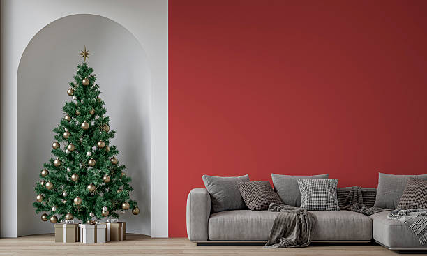 istock Modern minimalist interior decorated for Christmas, with sofa in front of red plaster wall, a Christmas tree with presents in a wall niche, near a window 2247463259