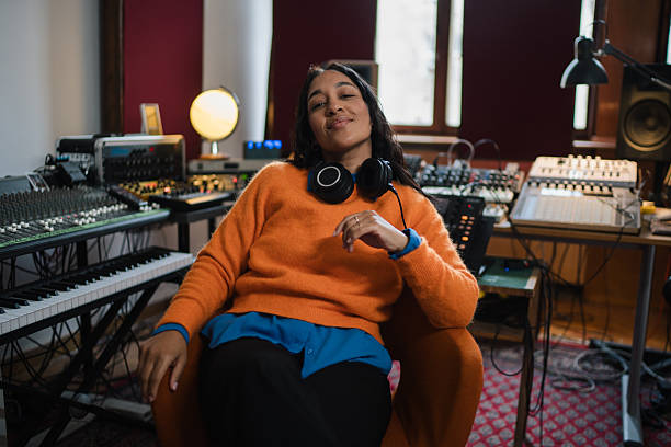 Female musician smiling in sound recording studio