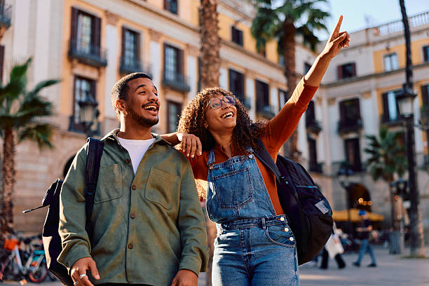 istock Happy diverse couple exploring Barcelona city pointing up 2247464884