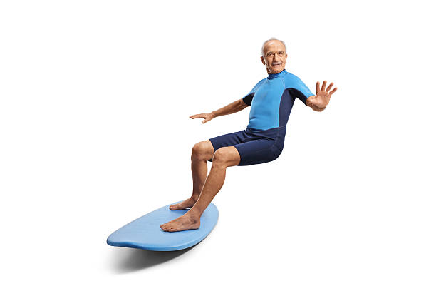 istock Elderly man in a wetsuit riding a surfboard 2247466019