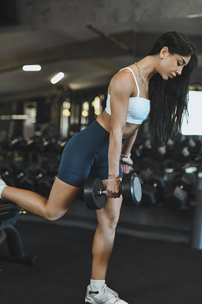 istock Strong Female Athlete Demonstrates Dumbbell Deadlift Exercise In A Modern Gym Setting During Workout Session 2247467098